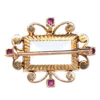 Edwardian 18ct gold brooch featuring aquamarine, ruby accents, and a pearl swirl design, suitable for all wearers.