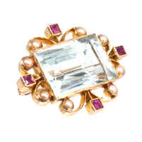 Edwardian 18ct gold brooch featuring aquamarine, ruby accents, and pearl detailing, a stunning vintage jewelry piece.
